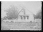 [Kansas] Photograph of two small children standing in front of a fence