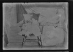 [Kansas] Photograph of infant sitting on rocking chair on a porch