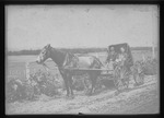 [Kansas] Photograph of two men in a horse-drawn wagon