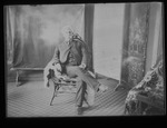 [Kansas] Photograph of man sitting on a chair in studio