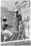 [Reynosa, CAV-Arriaga] Photograph of Tano Arriaga Passing Bricks to His Son During Kiln Unloading by Scott Cook