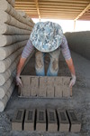[Reynosa, ELL-New] Photograph of Manuel Pasilla Releasing Wet Bricks onto a Drying Ground by Scott Cook