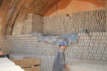 [Reynosa, ELL-New] Photograph of a Kiln Setter Placing Unfired Bricks in a Kiln by Scott Cook