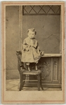 Child propped above a chair, front