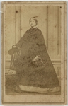 Woman in wide dress with one arm resting on chair, front by F. Kindler