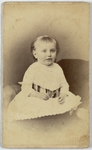 Girl with long dress with a sash wrapped around abdomen sitting on couch, front