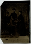 Two men and a woman pose before a decorative urn, front