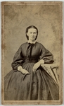 Woman with arm resting on table, three quarter length, facing forward, front