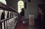 Older woman praying inside a church
