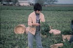Young child doing farm work in a field