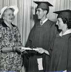 Photograph of Mary O'Brien handing out diplomas to two students