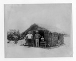 [Homesteads] Photograph of two Mexican men and a child in front of a jacal