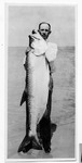 [South Padre Island] Photograph of fisherman next to large tarpon