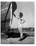 [South Padre Island] Photograph of woman next to hull of ship