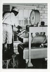 [Edinburg] Photograph of Worker Pouring Milk into Machinery