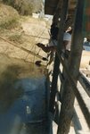 [Los Ebanos] Photograph of Man Filling Jar with Water from River